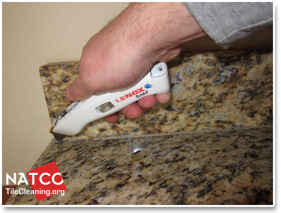 removing old caulk with utility knife